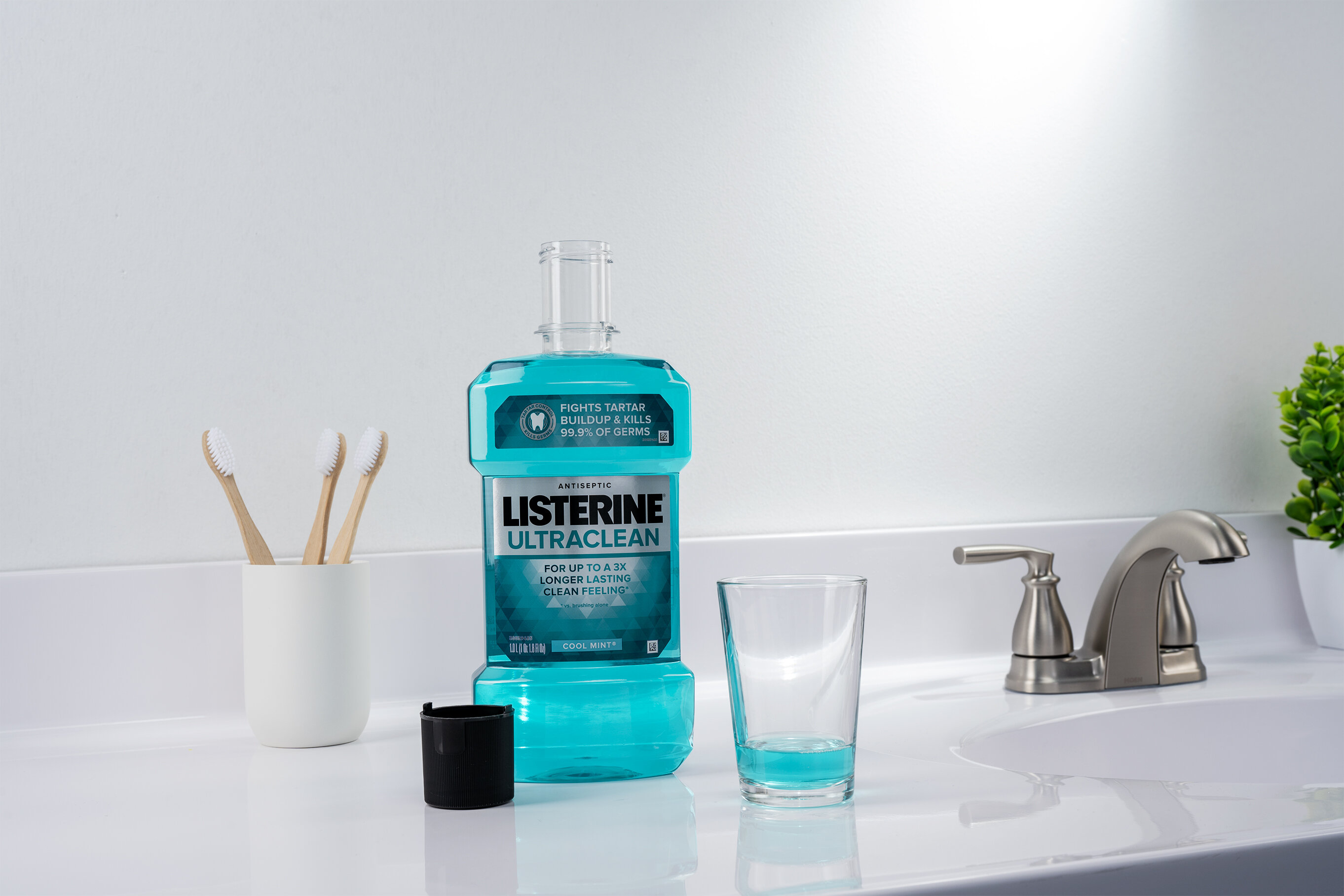 Listerine Ultraclean mouthwash with a cup in a sink